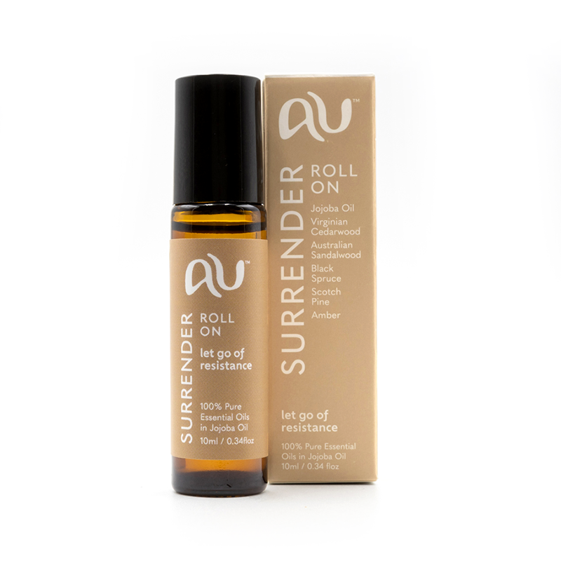 The Surrender Roll On is sitting on a white background next to its box. The bottle is long and slender with a beige label and black lid. The box is beige with white graphics.