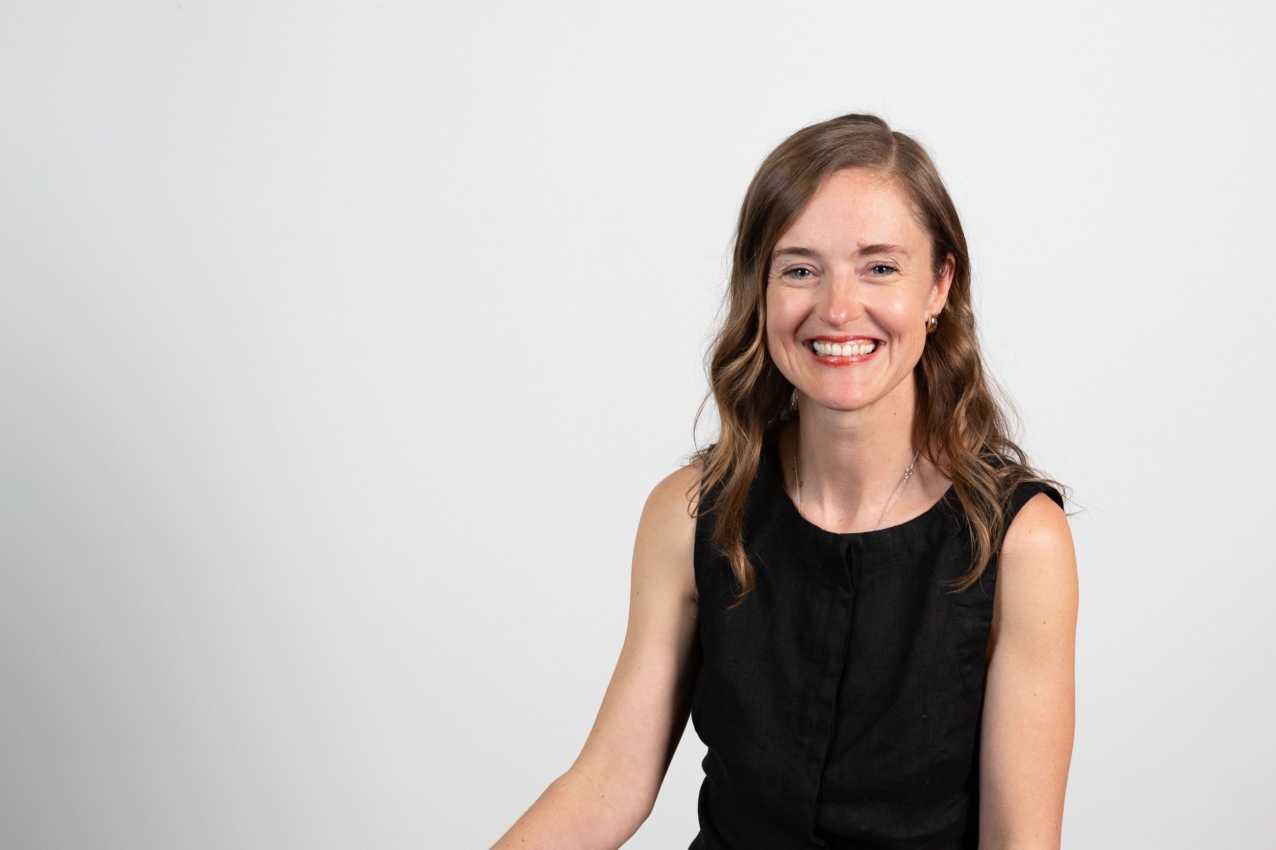 The practice manager in a sitting and smiling for a headshot