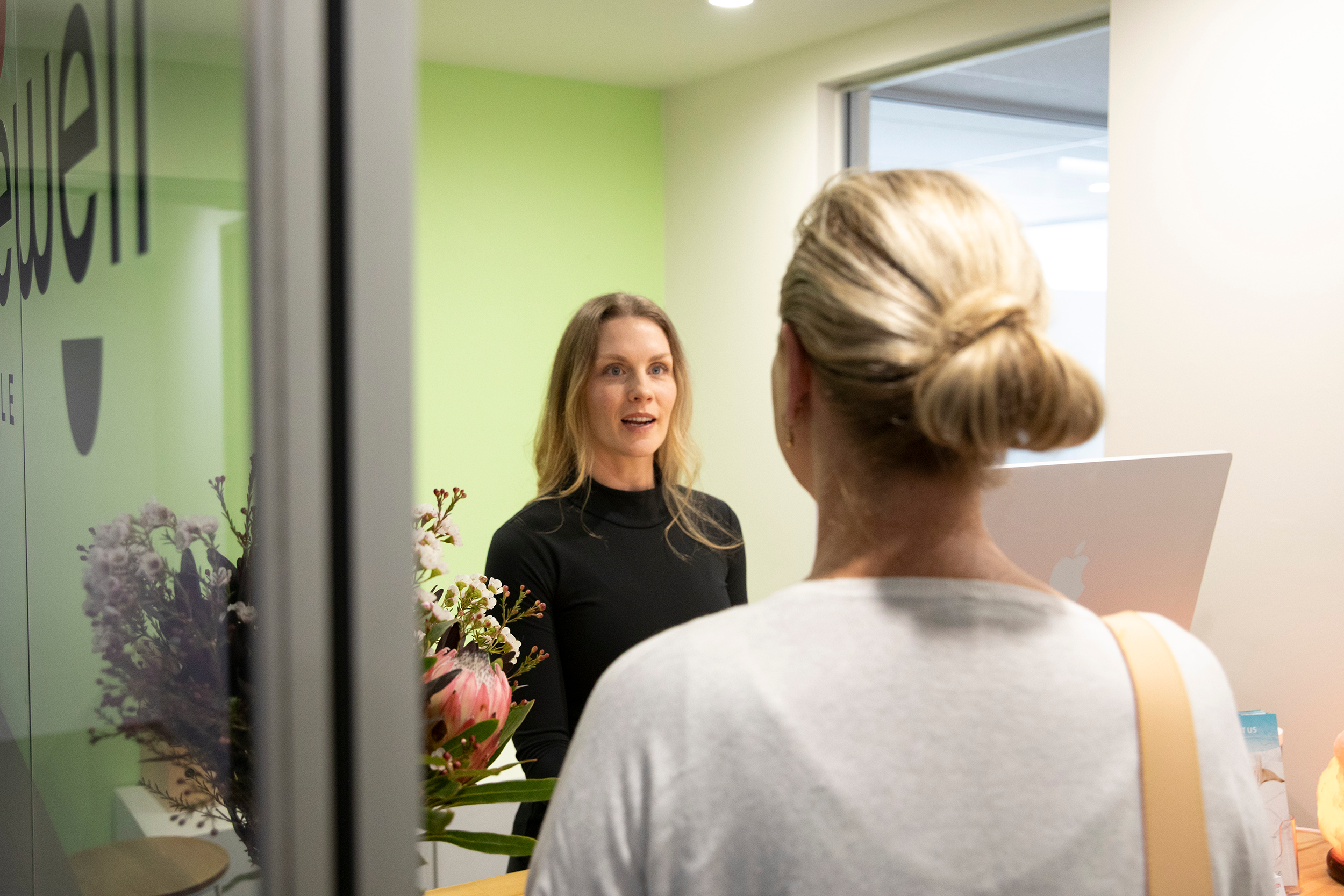 A view of the clinic reception with the receptionist talking to a client