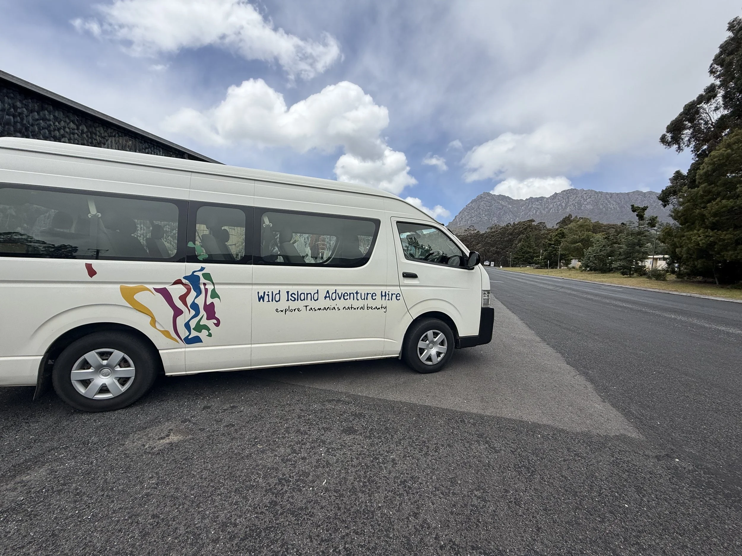 Wild Island Adventure bus providing Overland Track transfers with Mount Roland behind