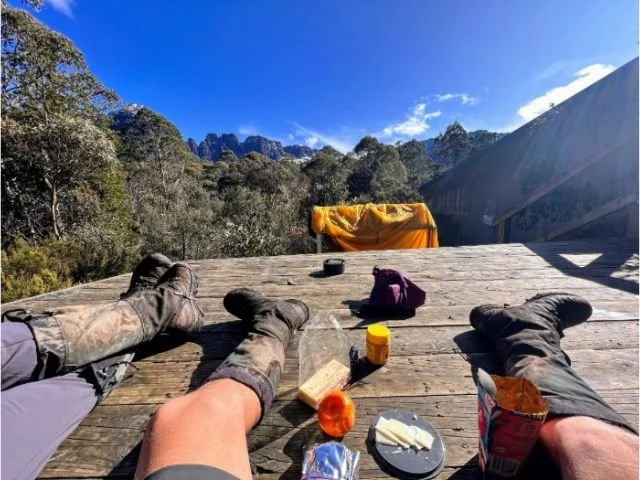 hikers relaxing on platform on the overland track