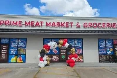 Prime Meat Market & Grocery store storefront decorated with balloons for opening or special event.