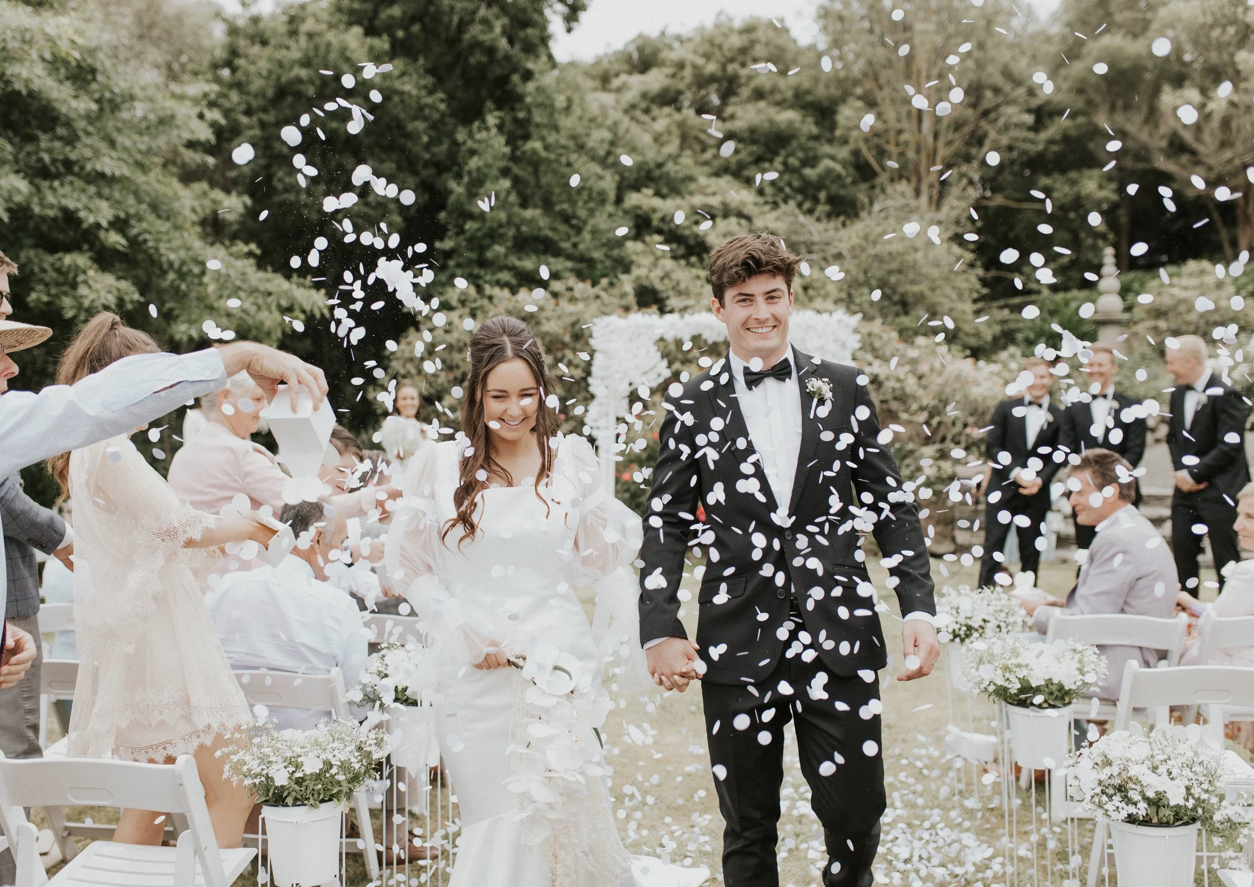 Couple covered in confetti celebrating just after their wedding ceremony.