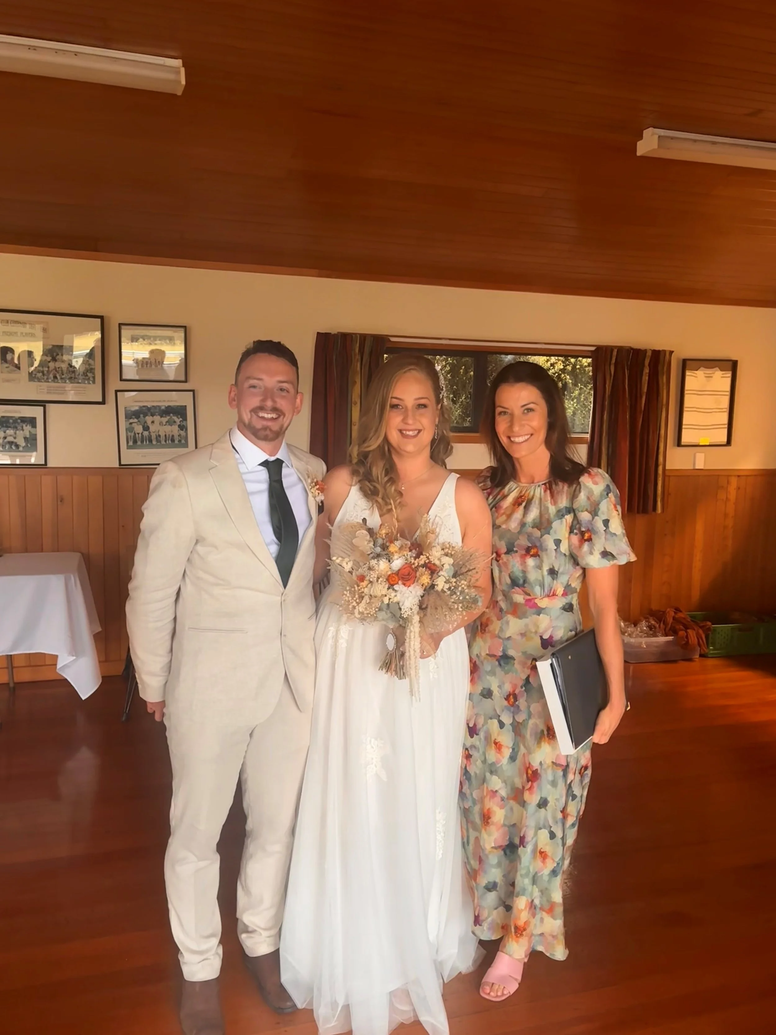 Celebrant Ollie van der Pol with a couple after their wedding ceremony in a community hall near West Melton on a rainy day.