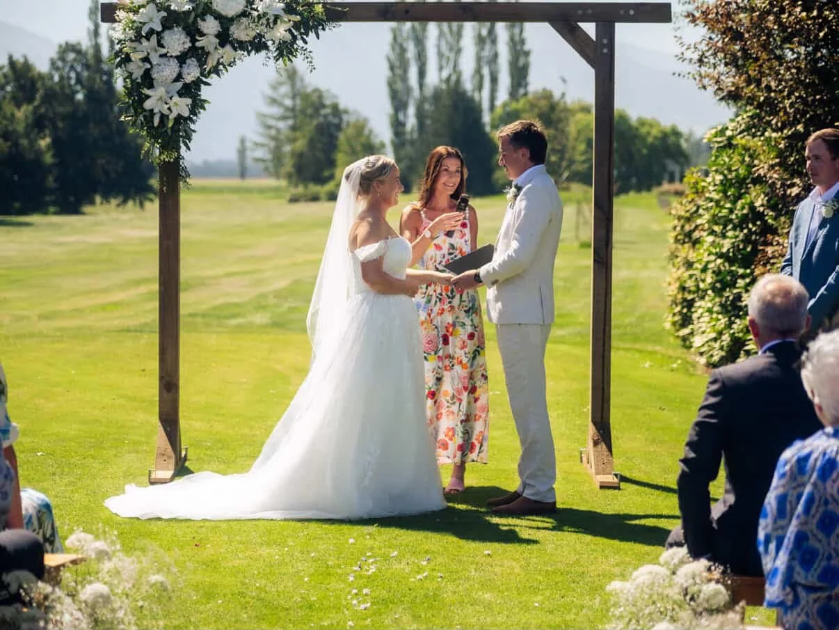 Ollie celebrating a couple’s wedding ceremony outdoors at Methven Golf Course, with the Southern Alps in the background