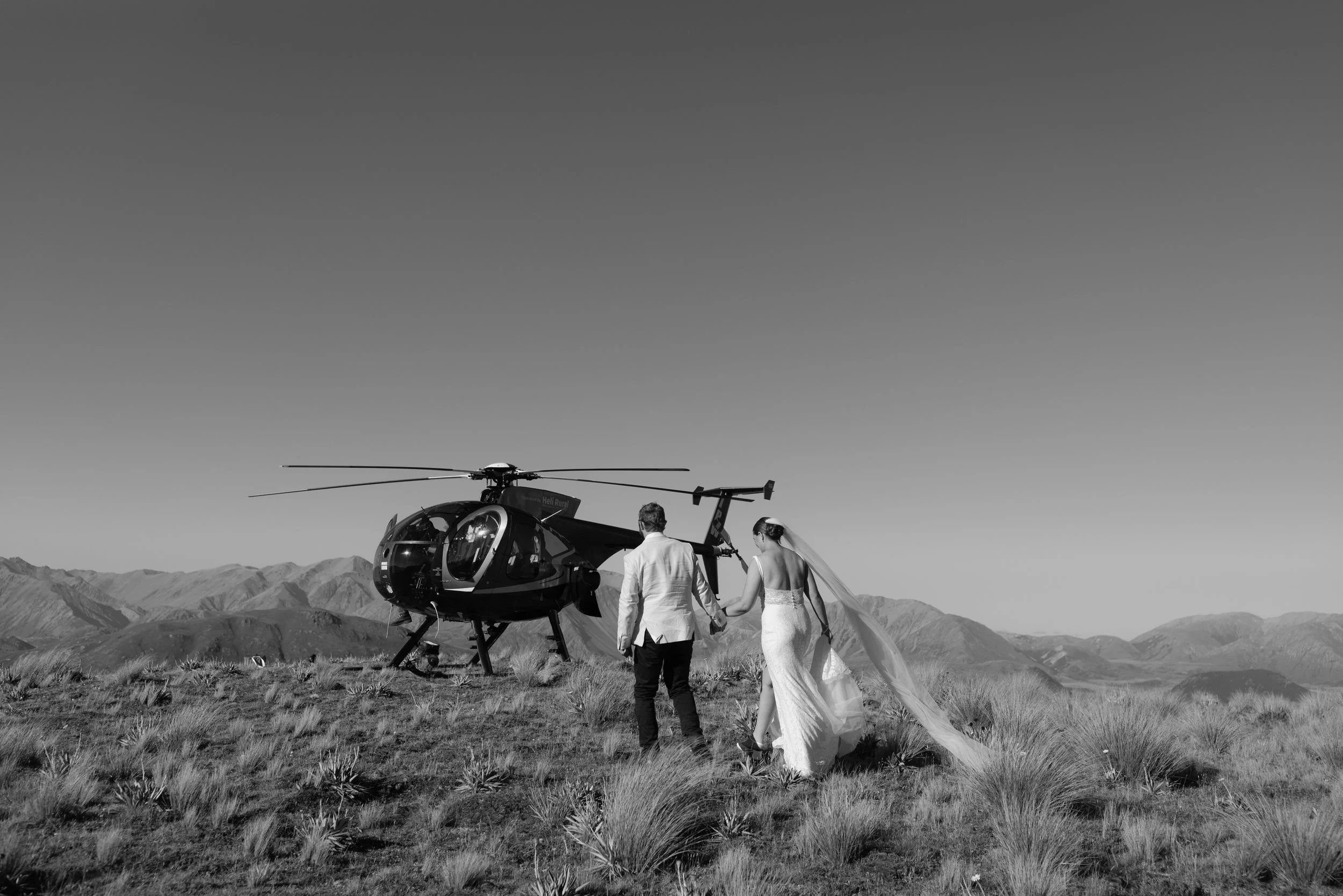 Couple in a helicopter flying over the Southern Alps during their wedding experience.