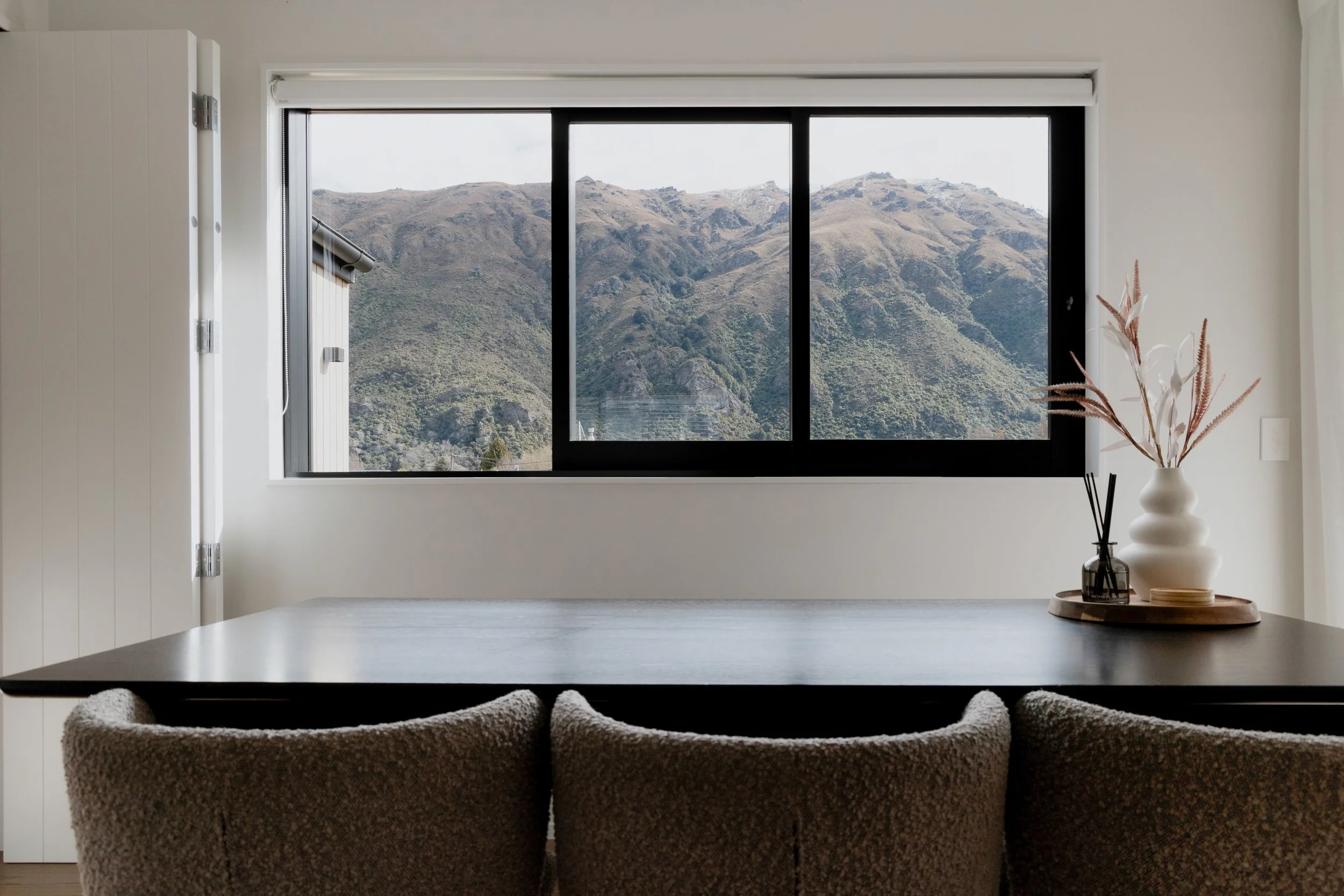 The view over the dining table and out the window towards the hills in a Kingston home built by Otago Homes Queenstown.