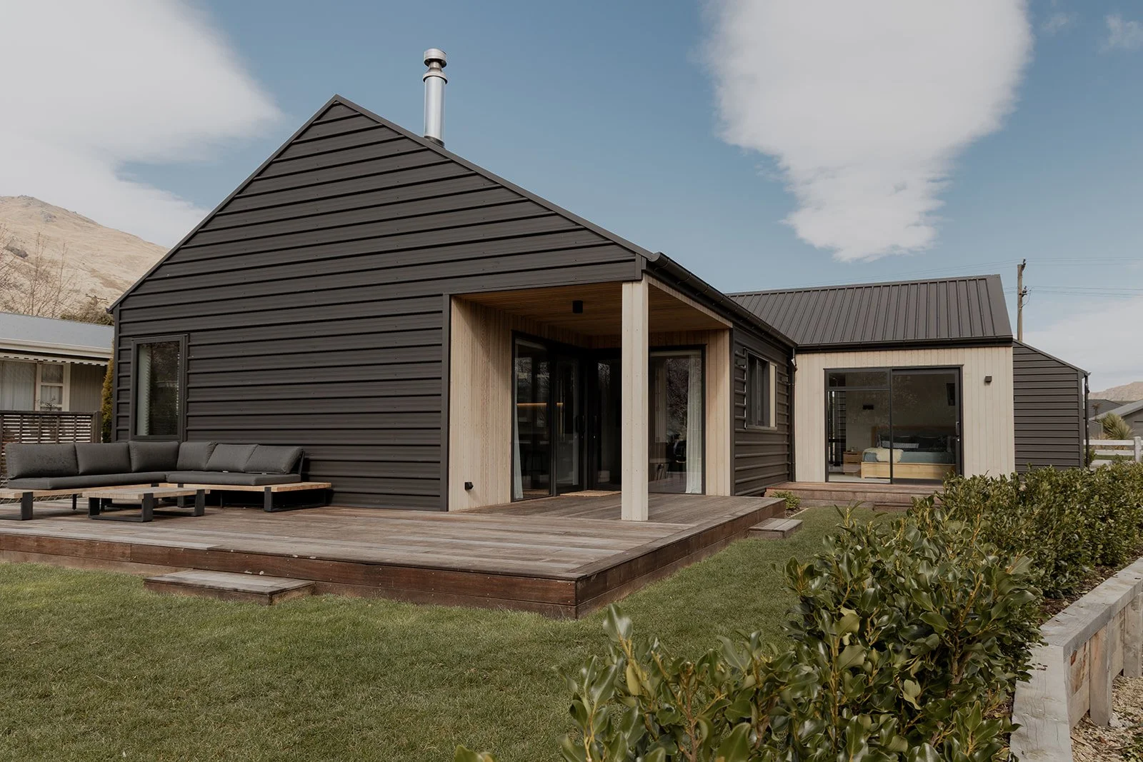 The exterior of a Kingston home with wrap around decking and Colour Steel cladding built by Otago Homes.