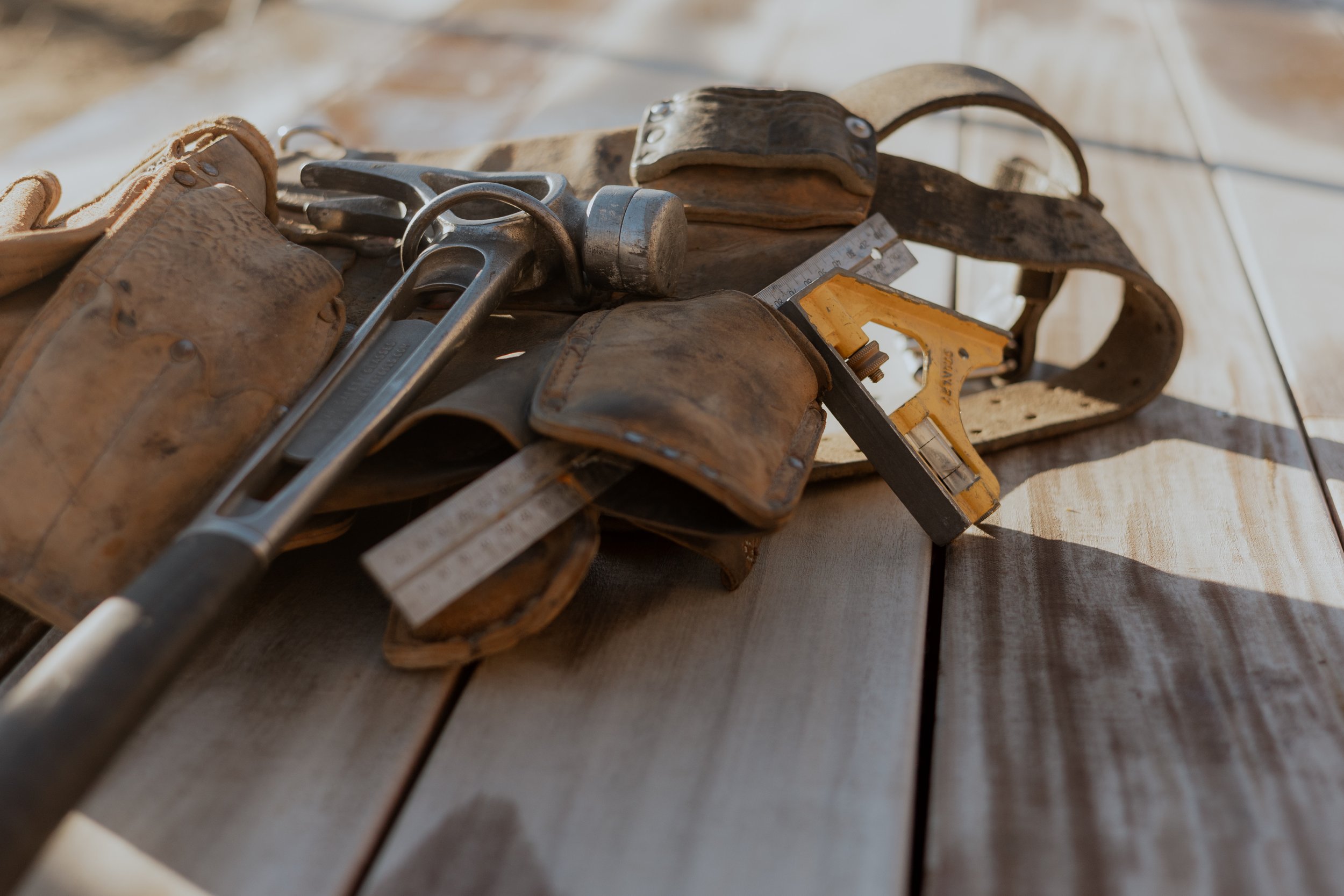 A tool belt lying across timber by Otago Homes Queenstown.