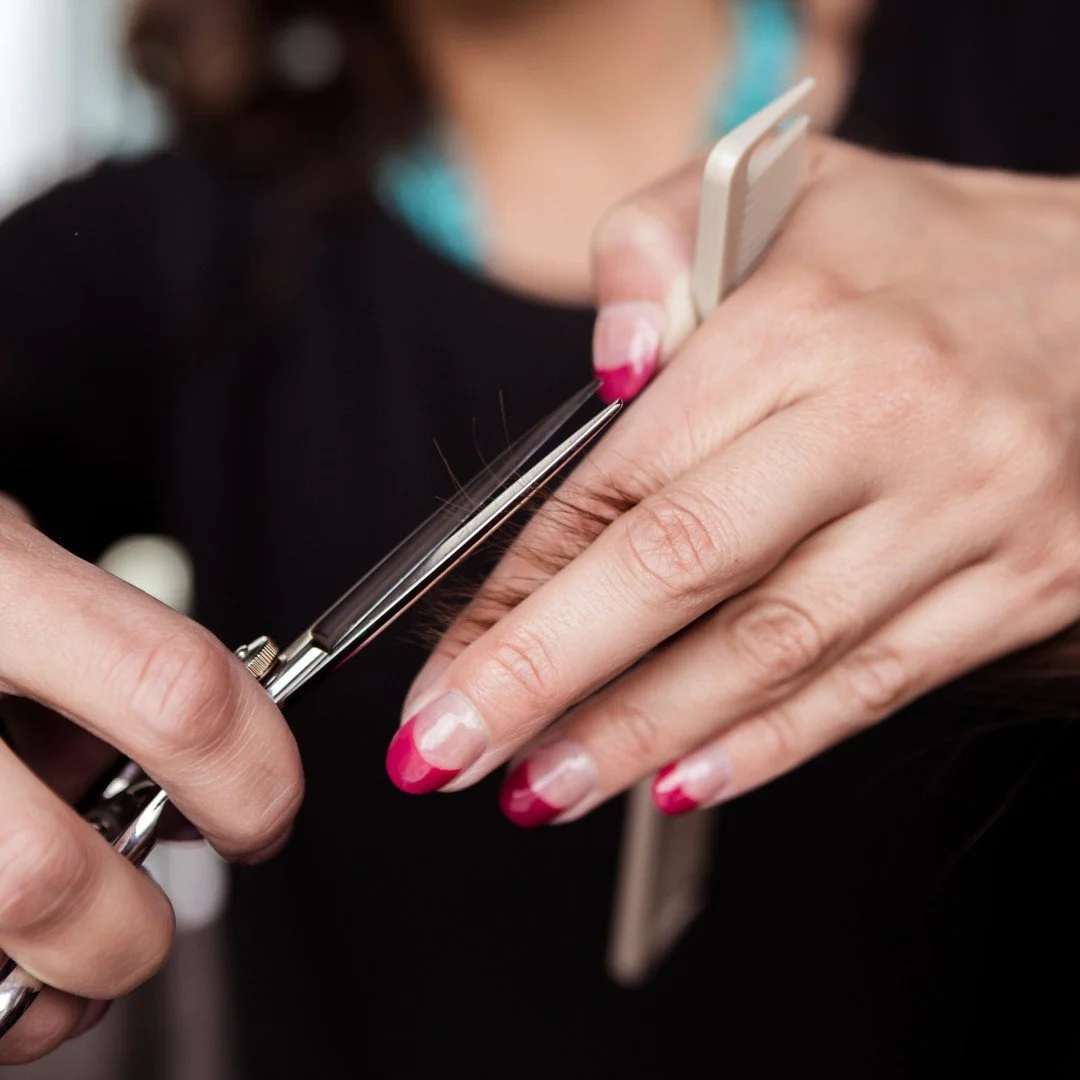 A person using nail scissors to trim fingernails.