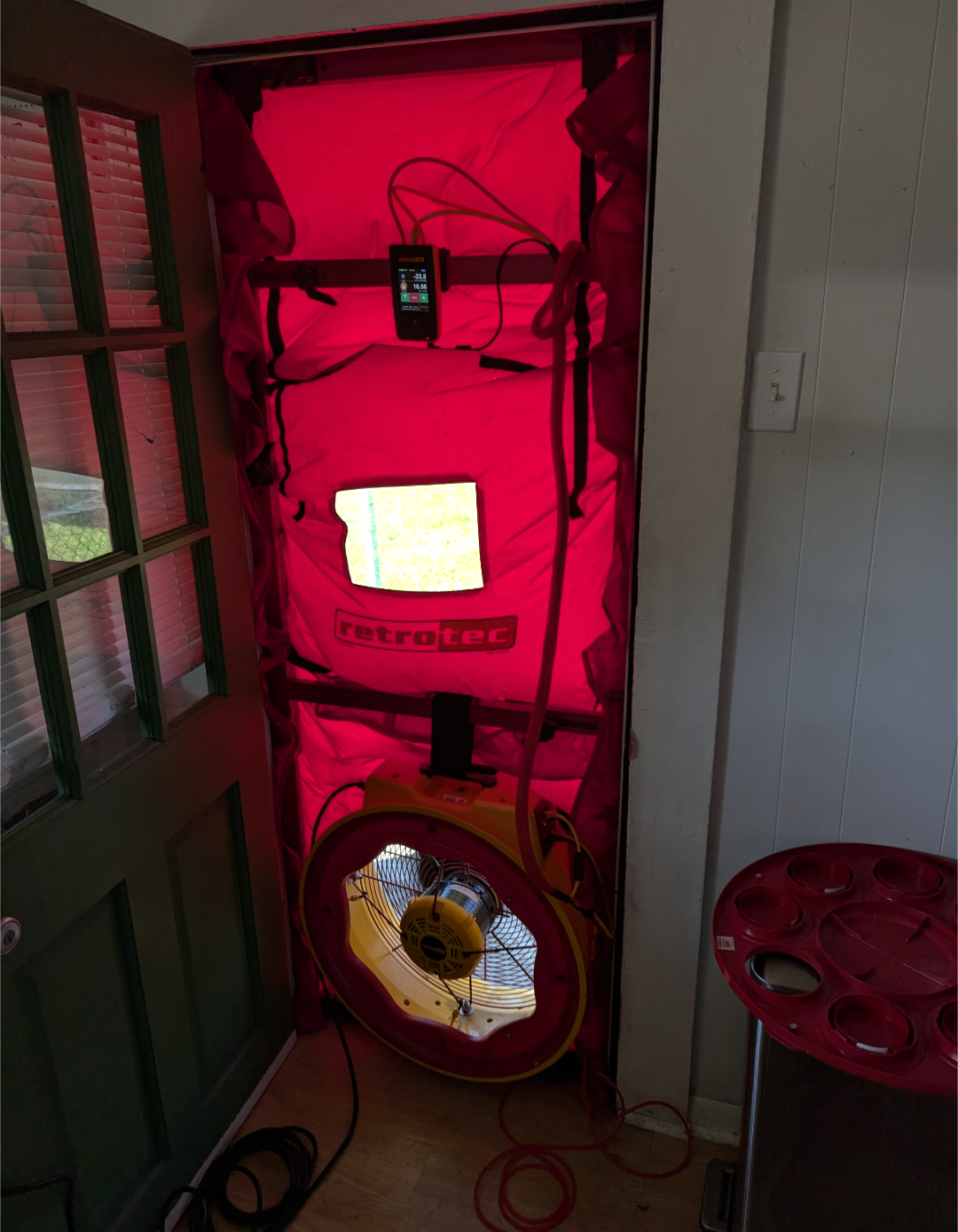Retrotec blower door system set up in residential doorway for envelope leakage testing