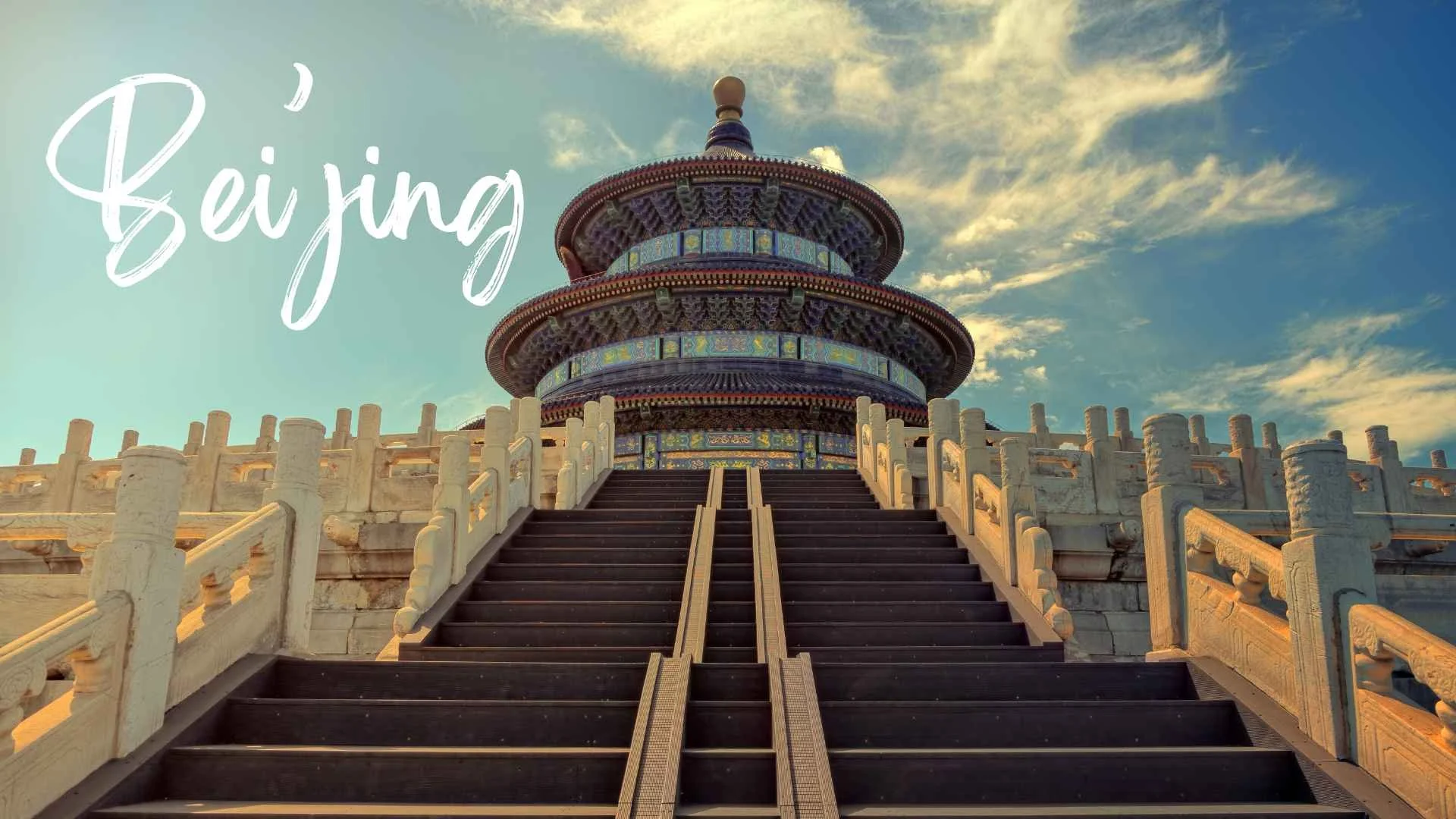 A traditional Chinese pagoda with intricate blue, green, and red tiles, set against a partly cloudy sky. A staircase with white stone railings leads up to the pagoda. The image contains the word "Beijing" written in white cursive text in the top left