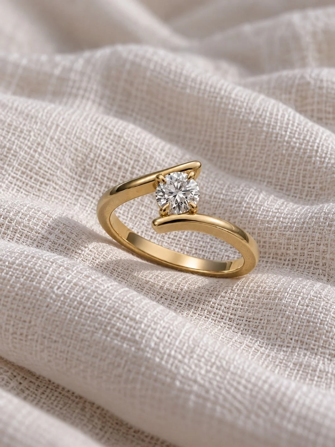 Bespoke 1ct GIA-certified round brilliant diamond Crossover engagement ring handmade in 18ct yellow gold by Hatton Garden jeweller Daniel Greenberg.