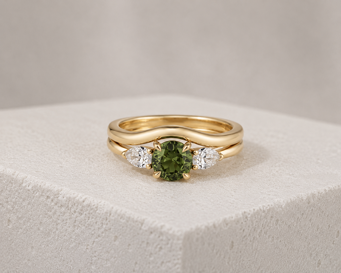 Gold ring with a central green gemstone flanked by two clear diamonds.