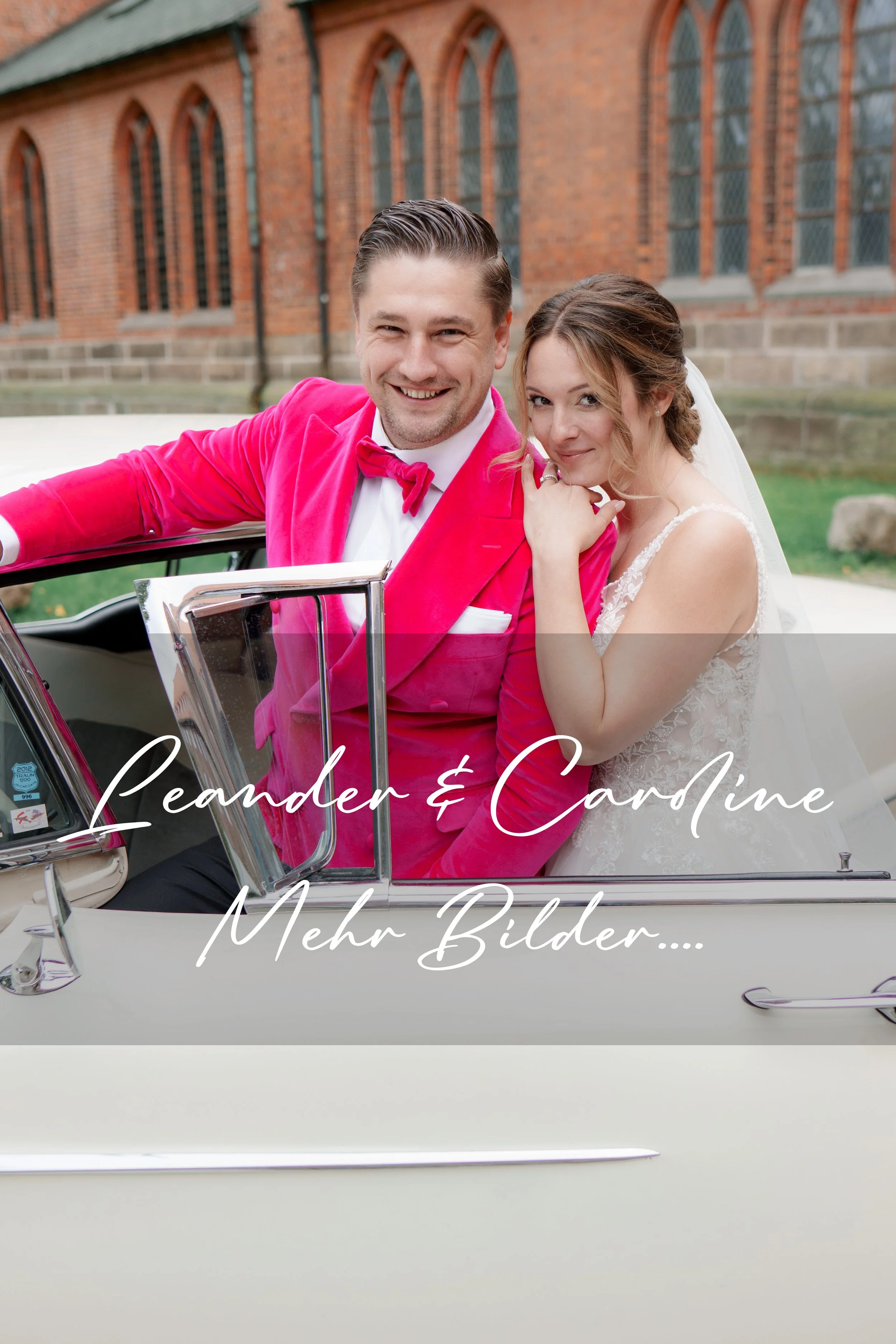 Ein lachendes Brautpaar in einem klassischen weißen Hochzeitskleid und einem Mann in einem pinken Anzug, sitzend in einem weißen Oldtimer vor einer Backstein-evangelischen Kirche. Dom Kirche zu Lübeck
