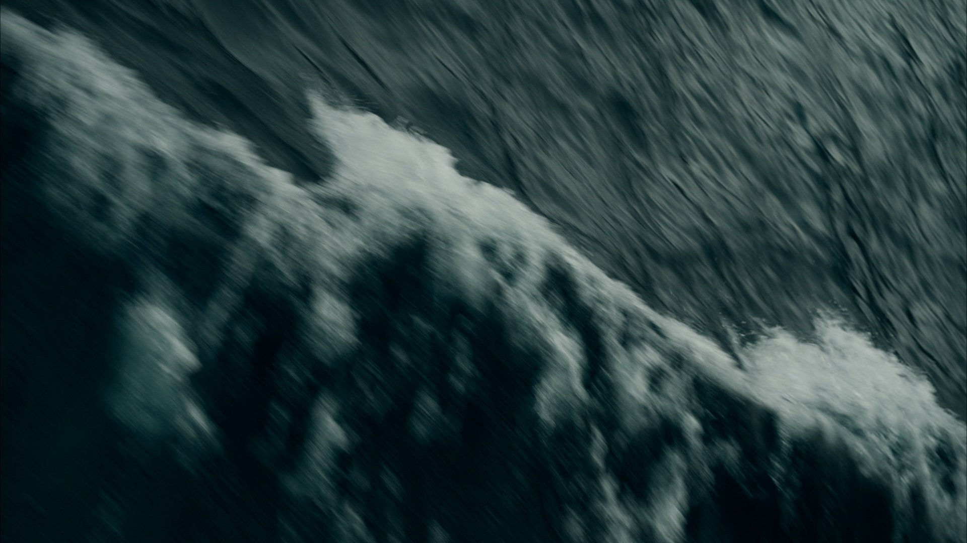 Close-up of ocean waves crashing and creating foam.