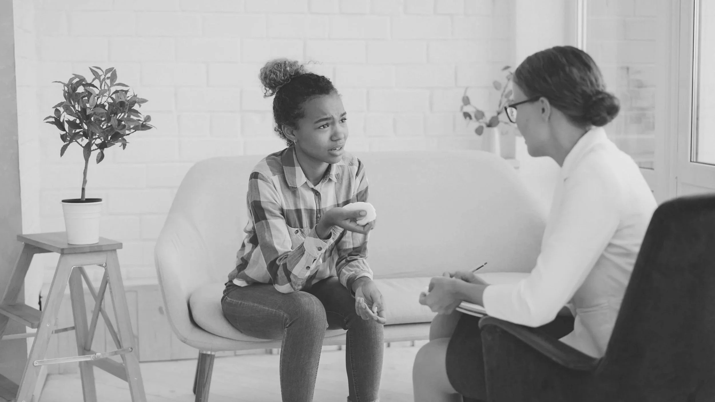 A young girl talking to a therapist or counselor in a counseling office