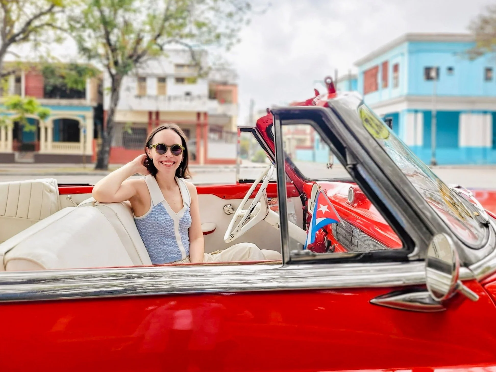 Woman sits in vintage convertible car in Havana, Cuba