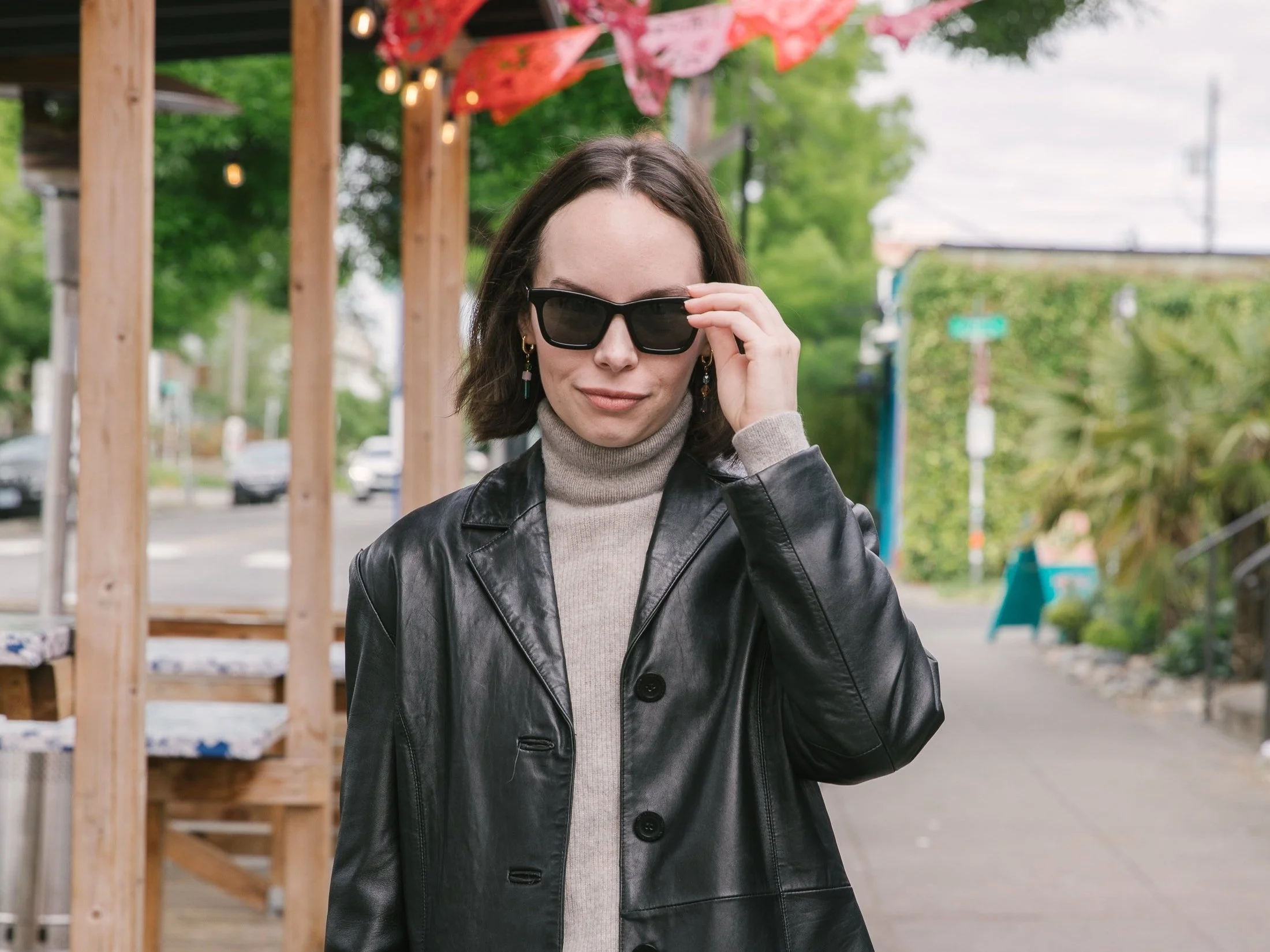 Woman in leather jacket poses for photo