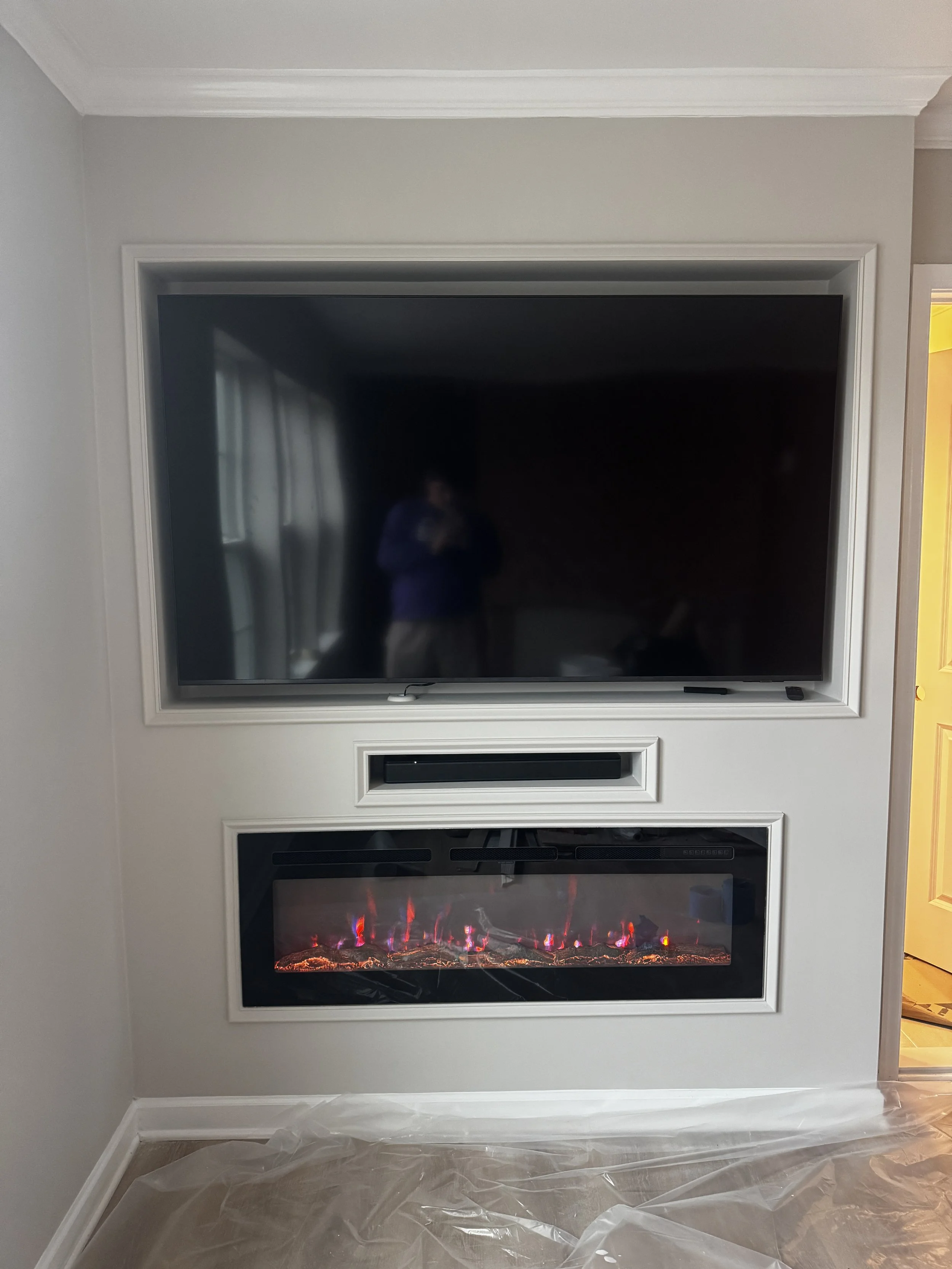 Custom media wall with electric fireplace and TV installation in Lewes, DE by Reyes Renovation