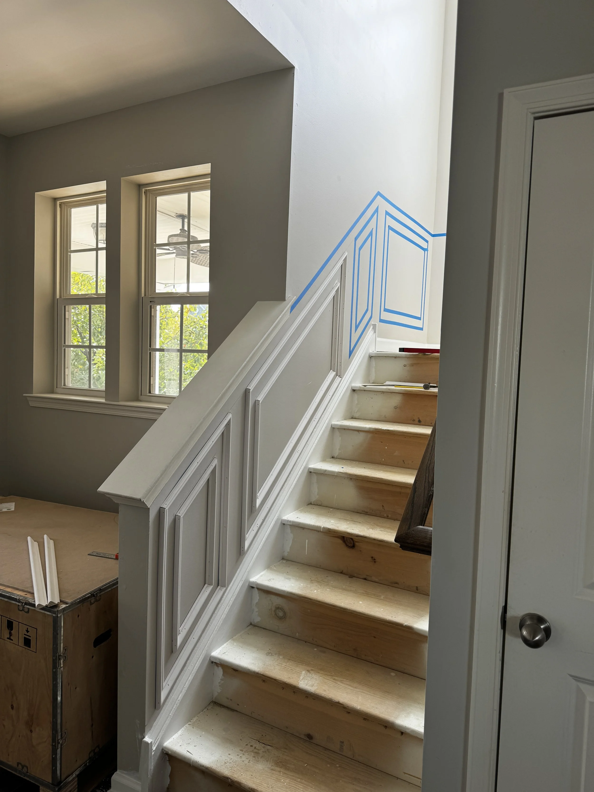 Staircase trim carpentry and accent wall paneling installation in Milton, DE by Reyes Renovation.