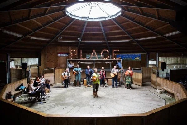 A group of musicians performing on a stage inside Hexham Mart.