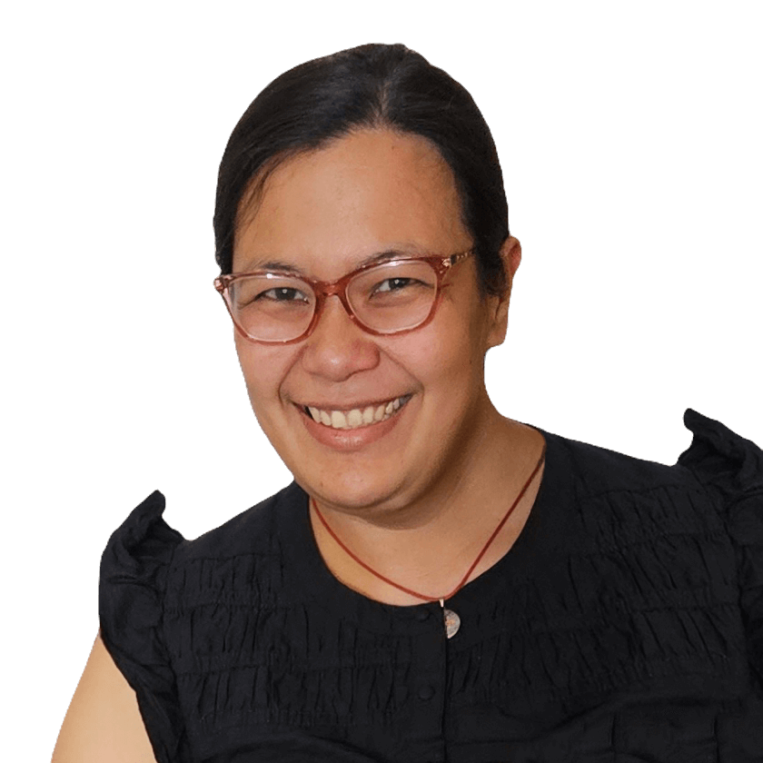 Audiologist at Clear Ears Perth professional picture. A woman with glasses and dark hair smiling at the camera, wearing a black top with ruffled sleeves and a red necklace.