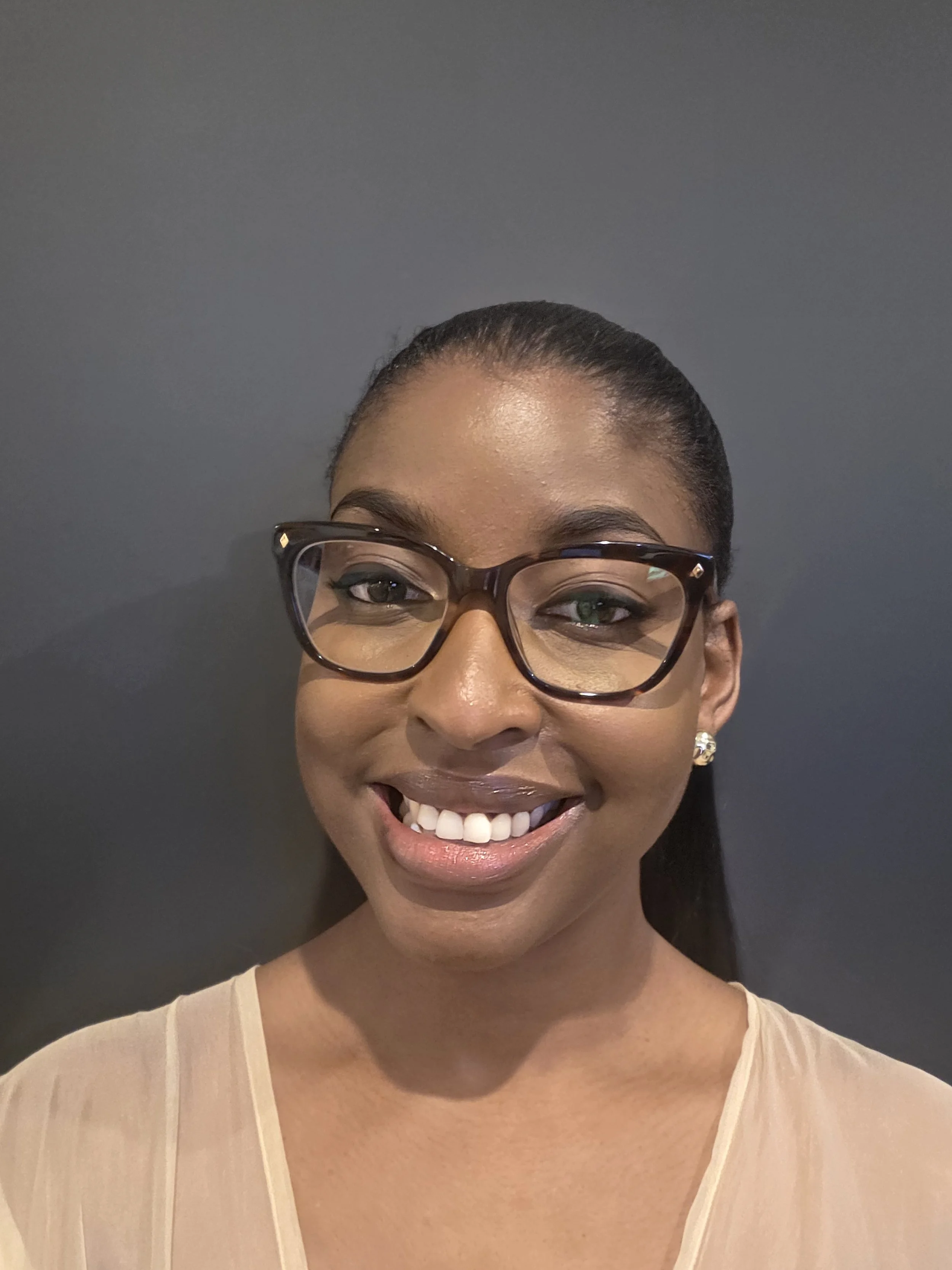 Audiologist working at Clear Ears Perth Tanya who has long dark hari and wears glasses and is smiling in a professional photo