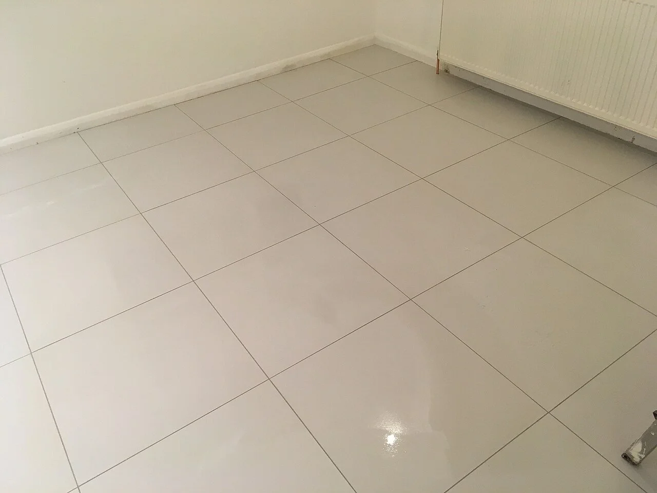 Large-format polished porcelain tile floor with grout lines