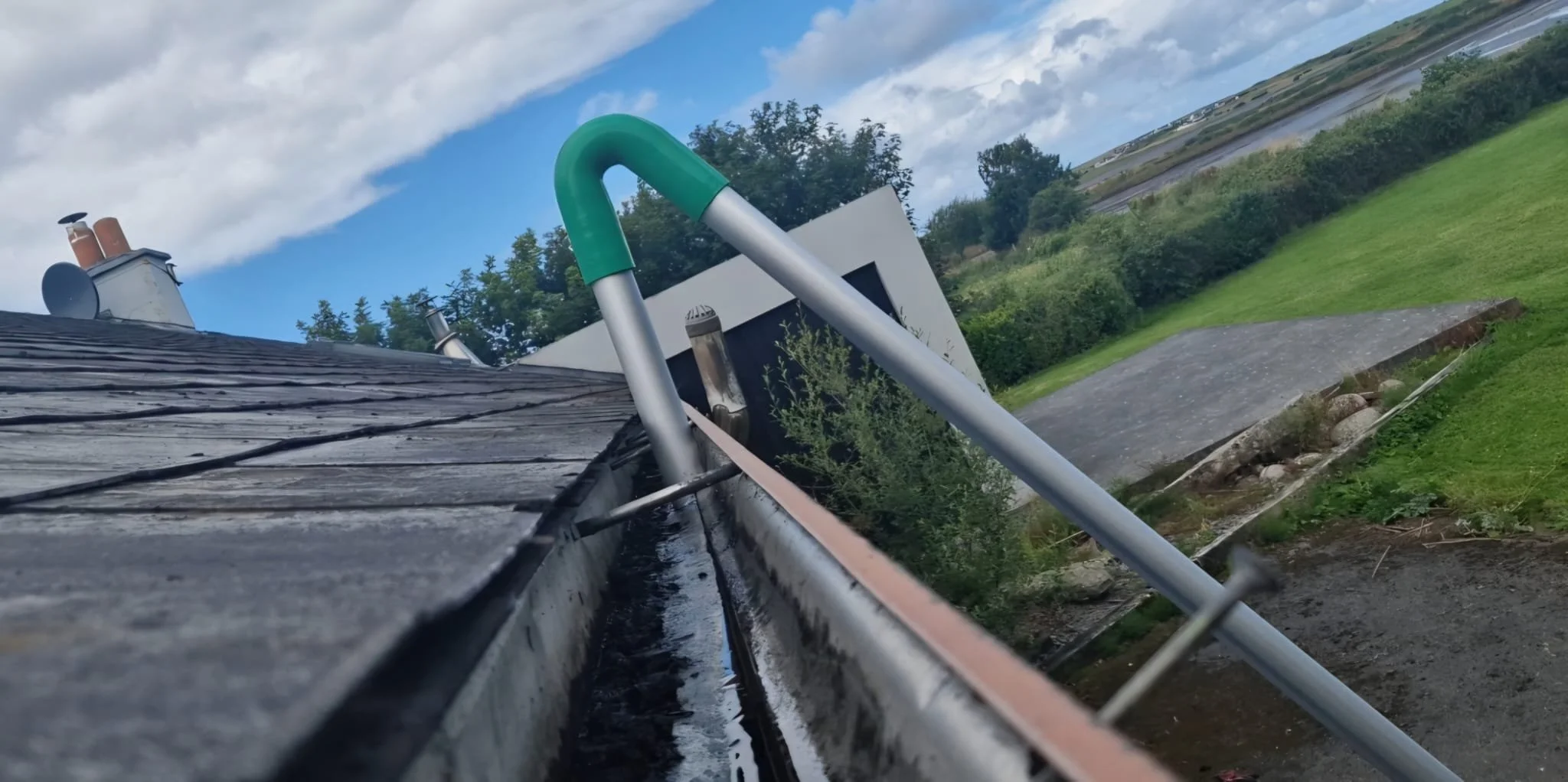 Professional gutter clearing using a high-reach gutter vacuum system