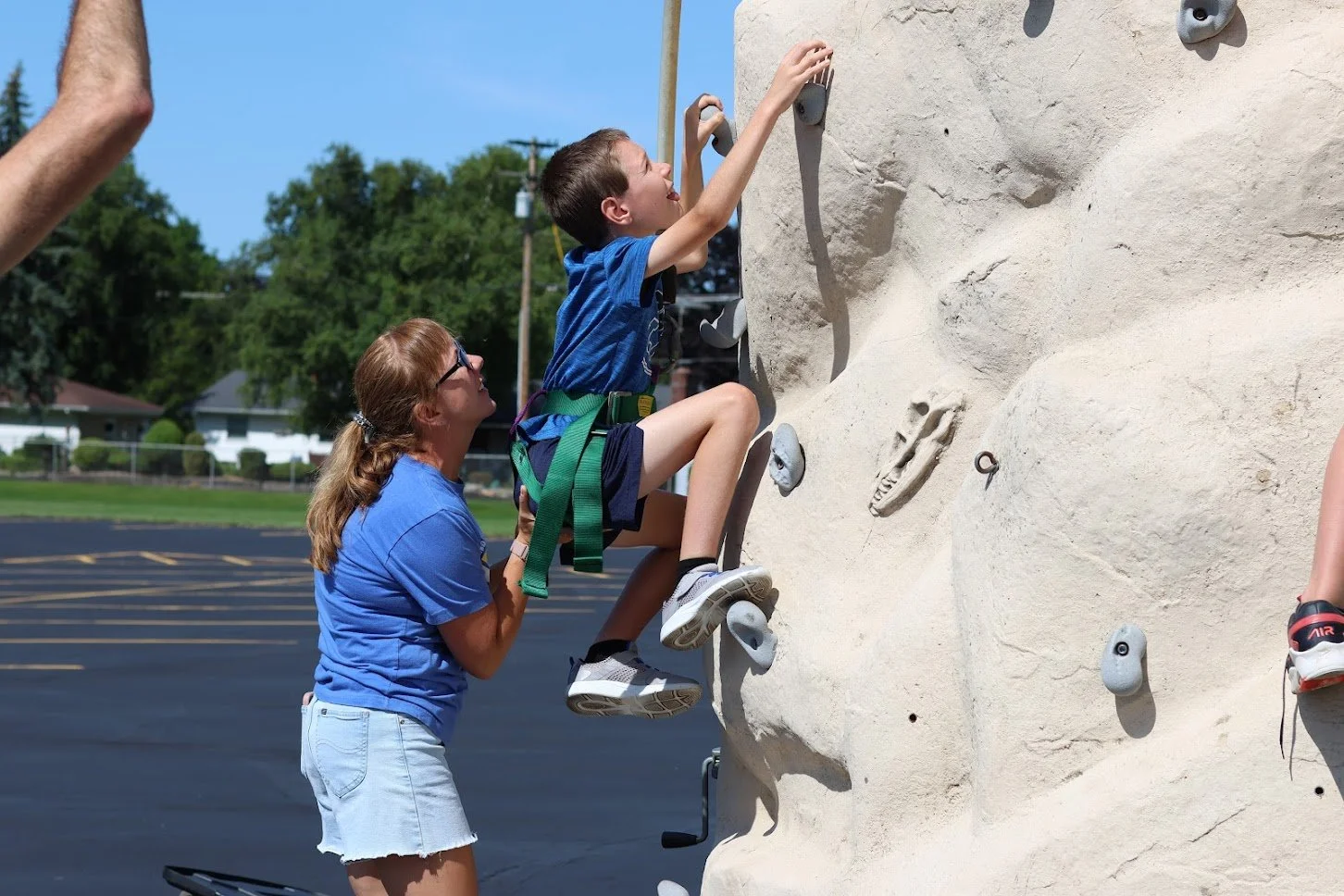 Mom helping kid climb wall