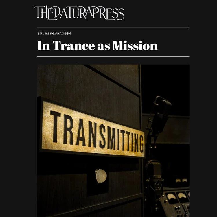 Portrait of a woman with short black hair, wearing a black outfit against a dark background.