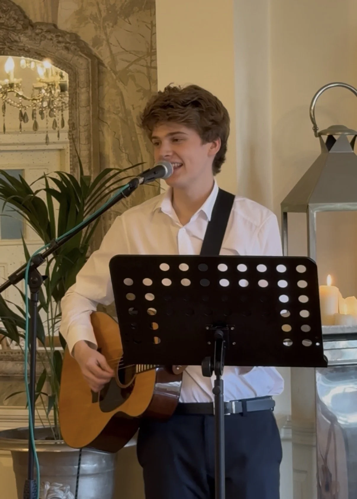 Oscar Flanagan singing at Eaves Hall wedding fair in November playing acoustic guitar