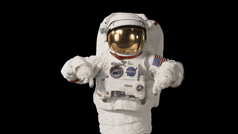 An astronaut in a white space suit giving two thumbs up against a black background.
