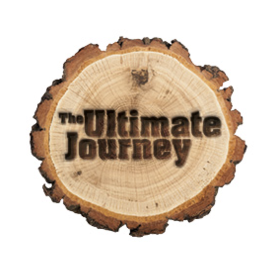 A circular piece of wood with the text 'The Ultimate Journey' burned or carved into it.