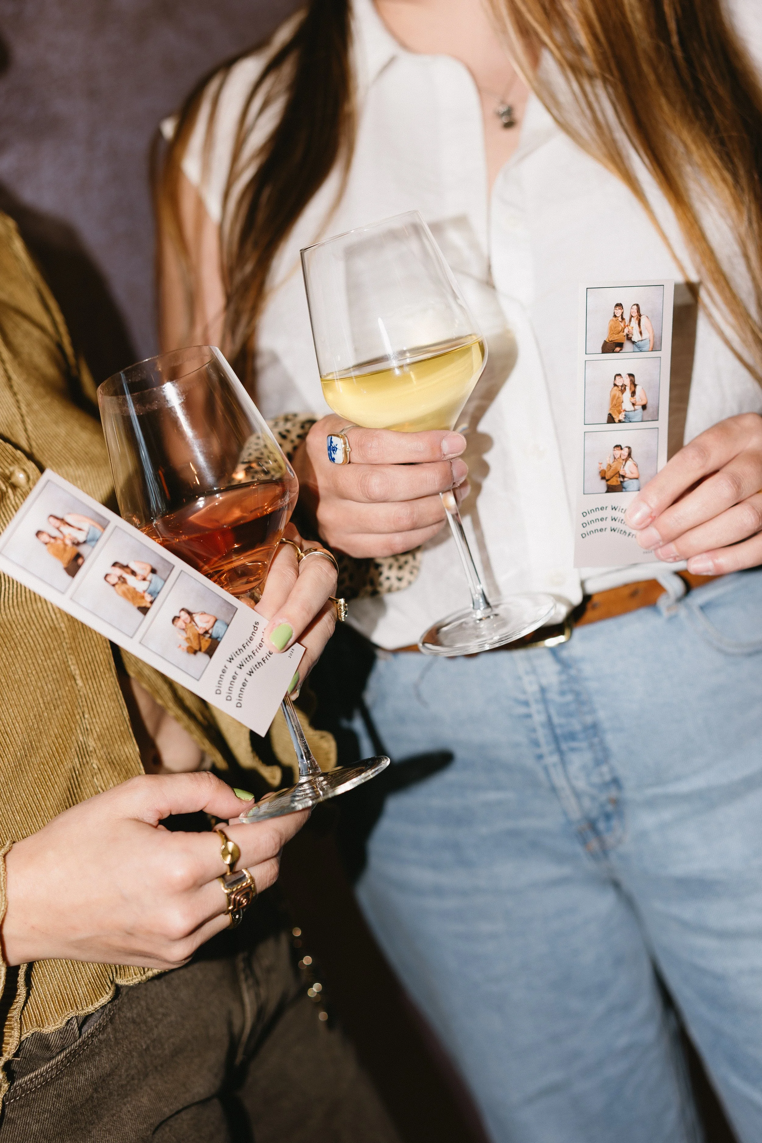 A woman in a dark dress looks at a wedding sign display at an event, with a lamp nearby and a man in the background.