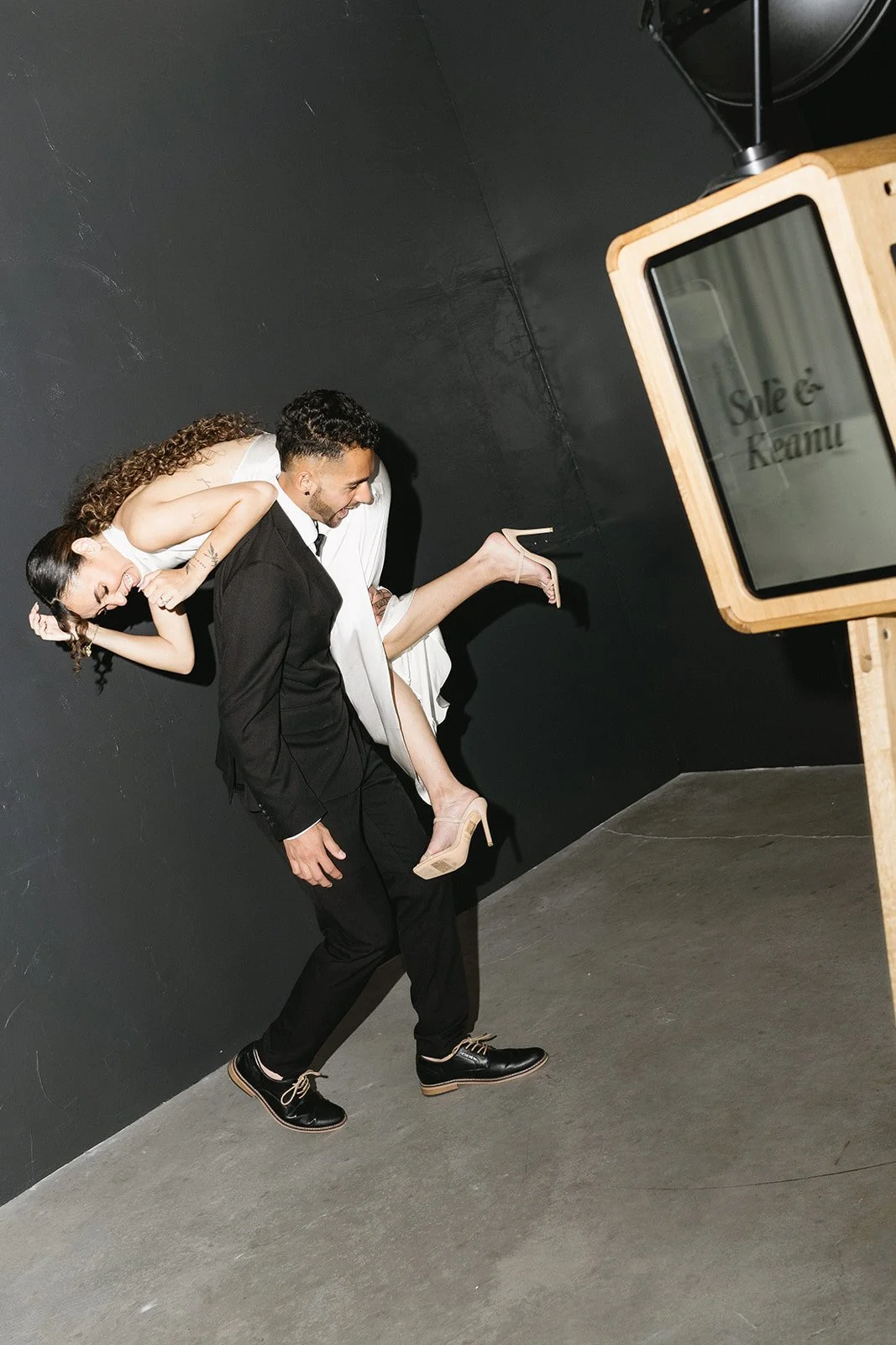 Wedding couple posing at a luxury photo booth rental during an elegant evening reception.