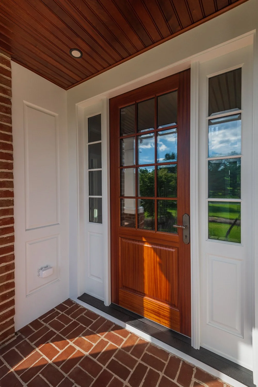  custom mahogany entry system with cornice roof, mahogany beadboard ceiling and integrated gutters in the pillars 