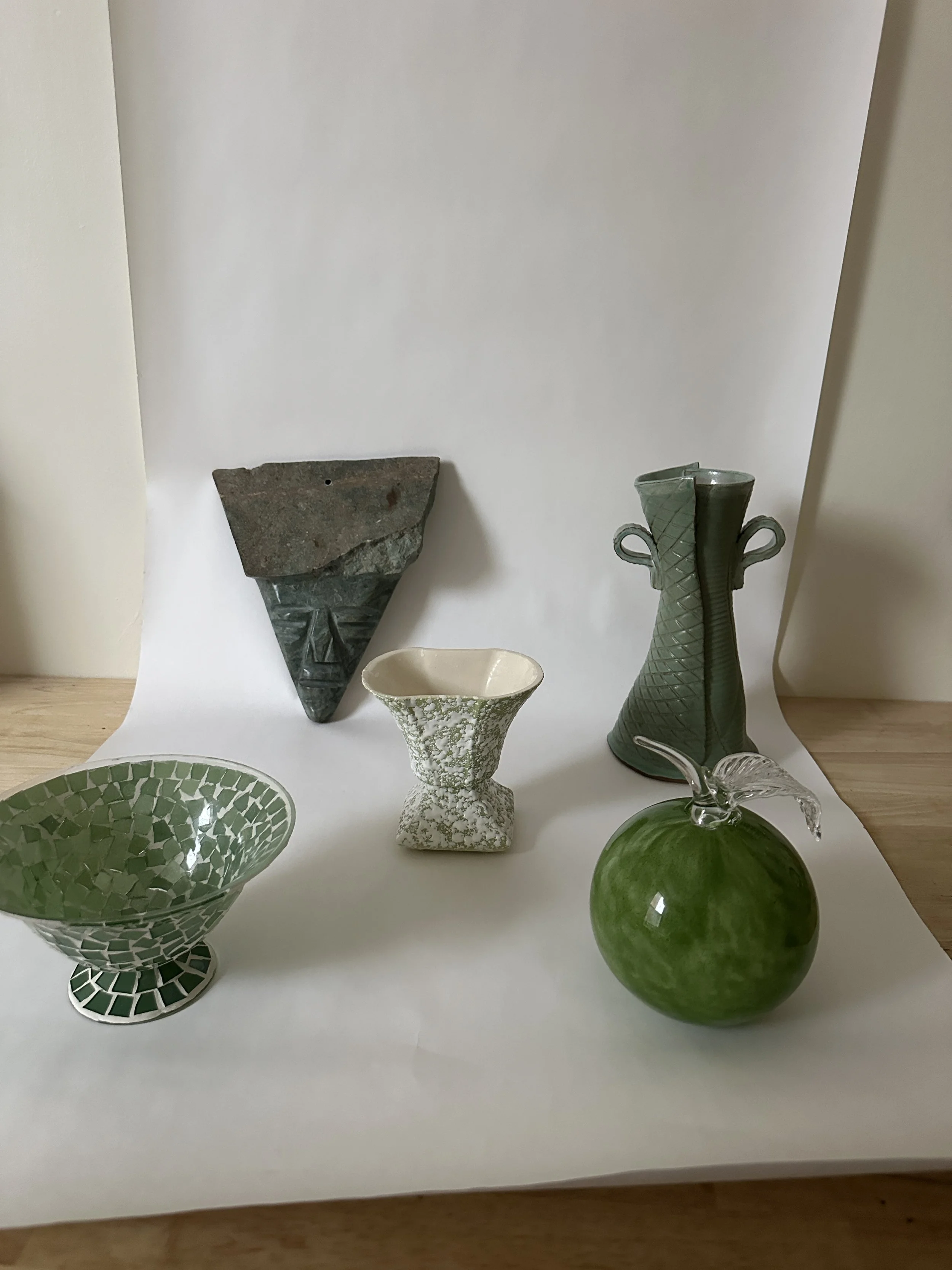 Collection of ceramic and glass vases and bowls on a white surface with a plain white background.