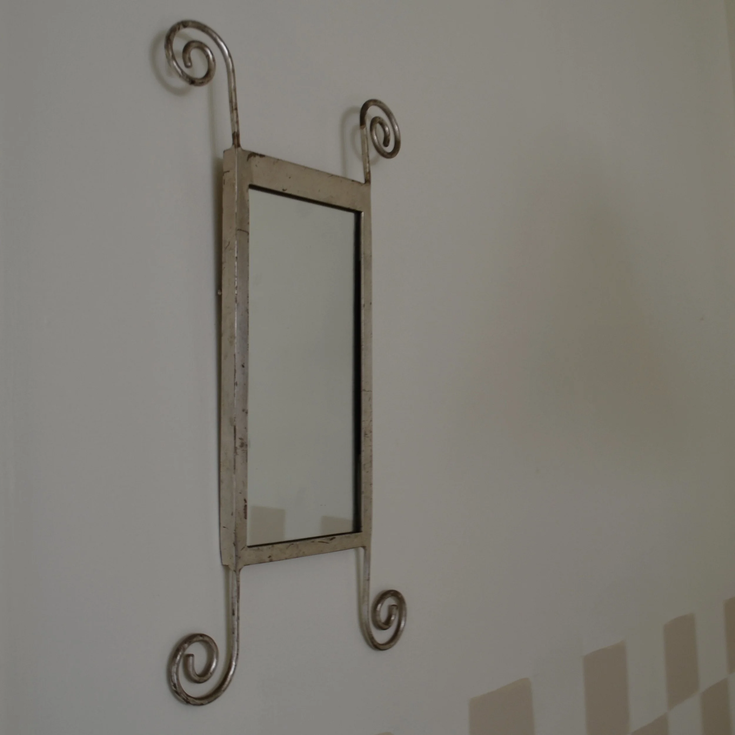 Metal wall hooks against a plain wall.