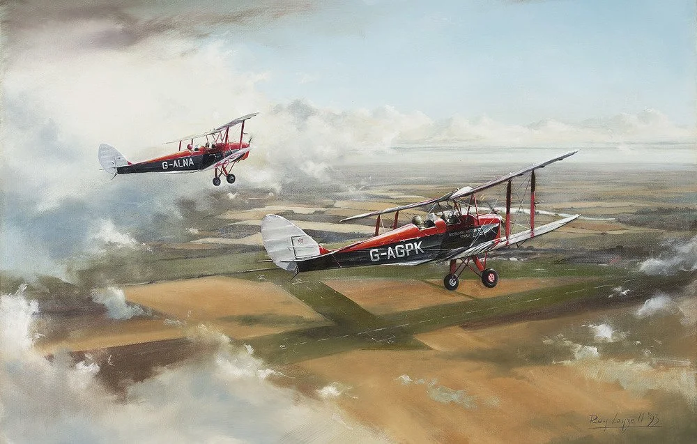Two vintage biplanes flying over a patchwork farmland landscape.