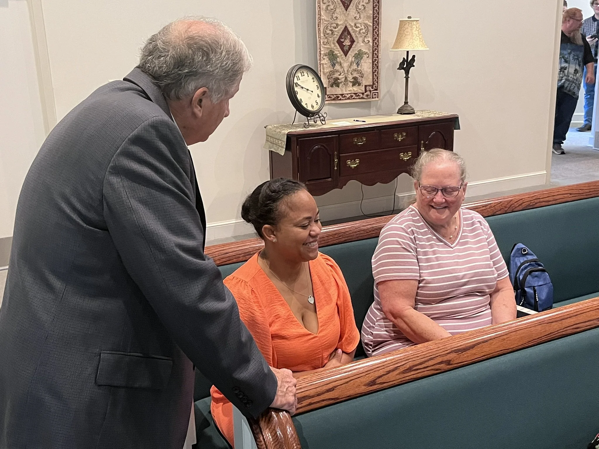 Powell Road members smiling and greeting one another before worship