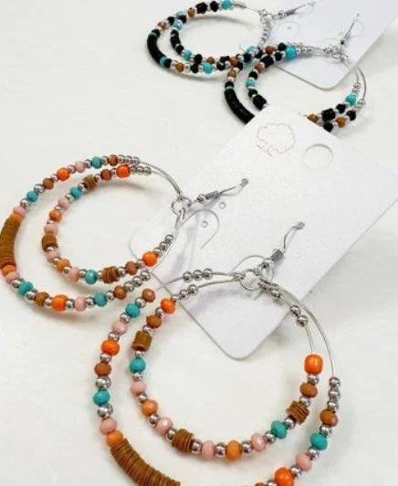 Three pairs of colorful beaded hoop earrings displayed on a white surface.