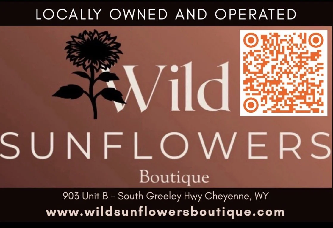 Business card for Wild Sunflowers Boutique, a locally owned and operated store, featuring a black sunflower logo, the store name, and a QR code.