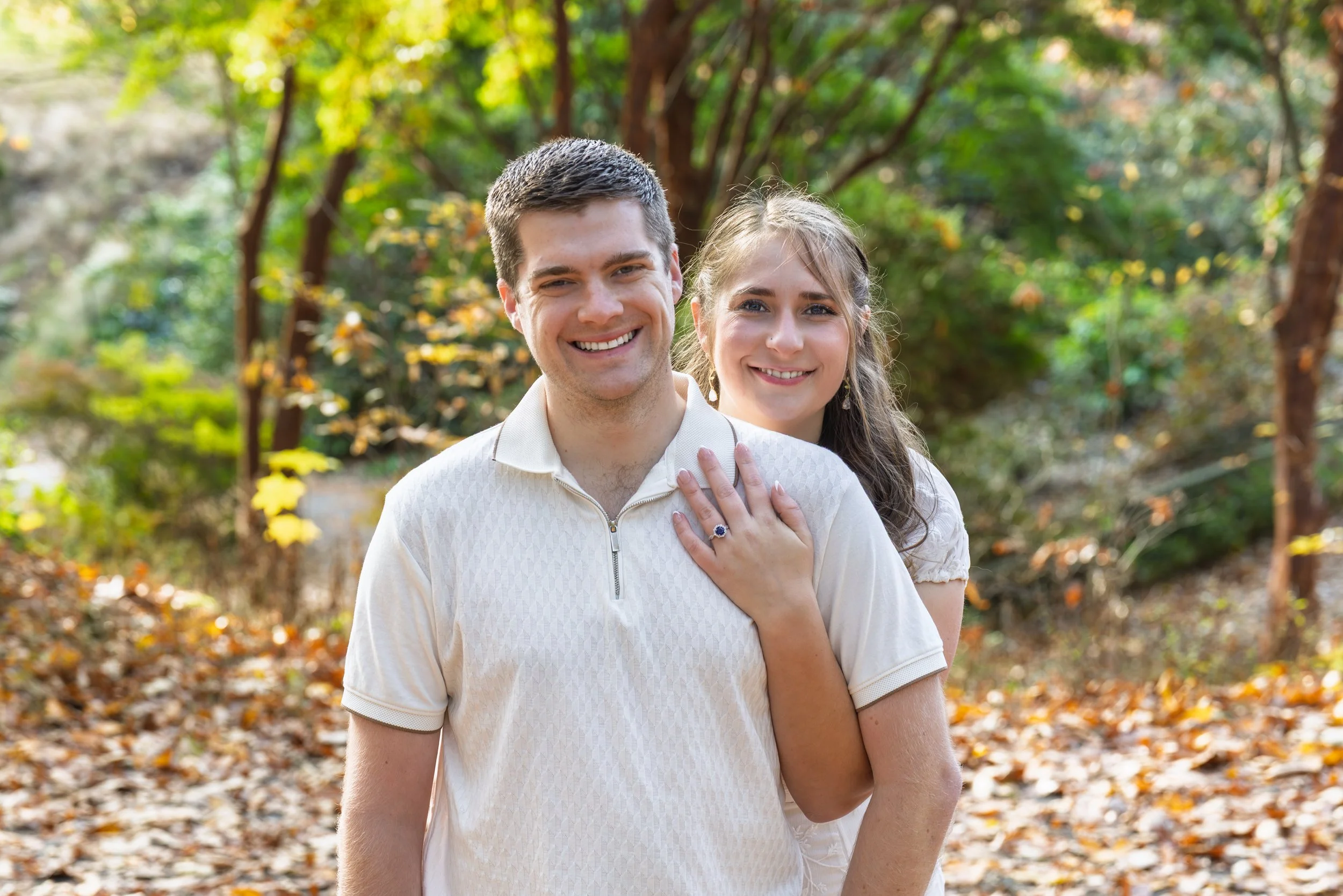 A young man and woman sitting on steps in front of a yellow door, smiling and hugging.