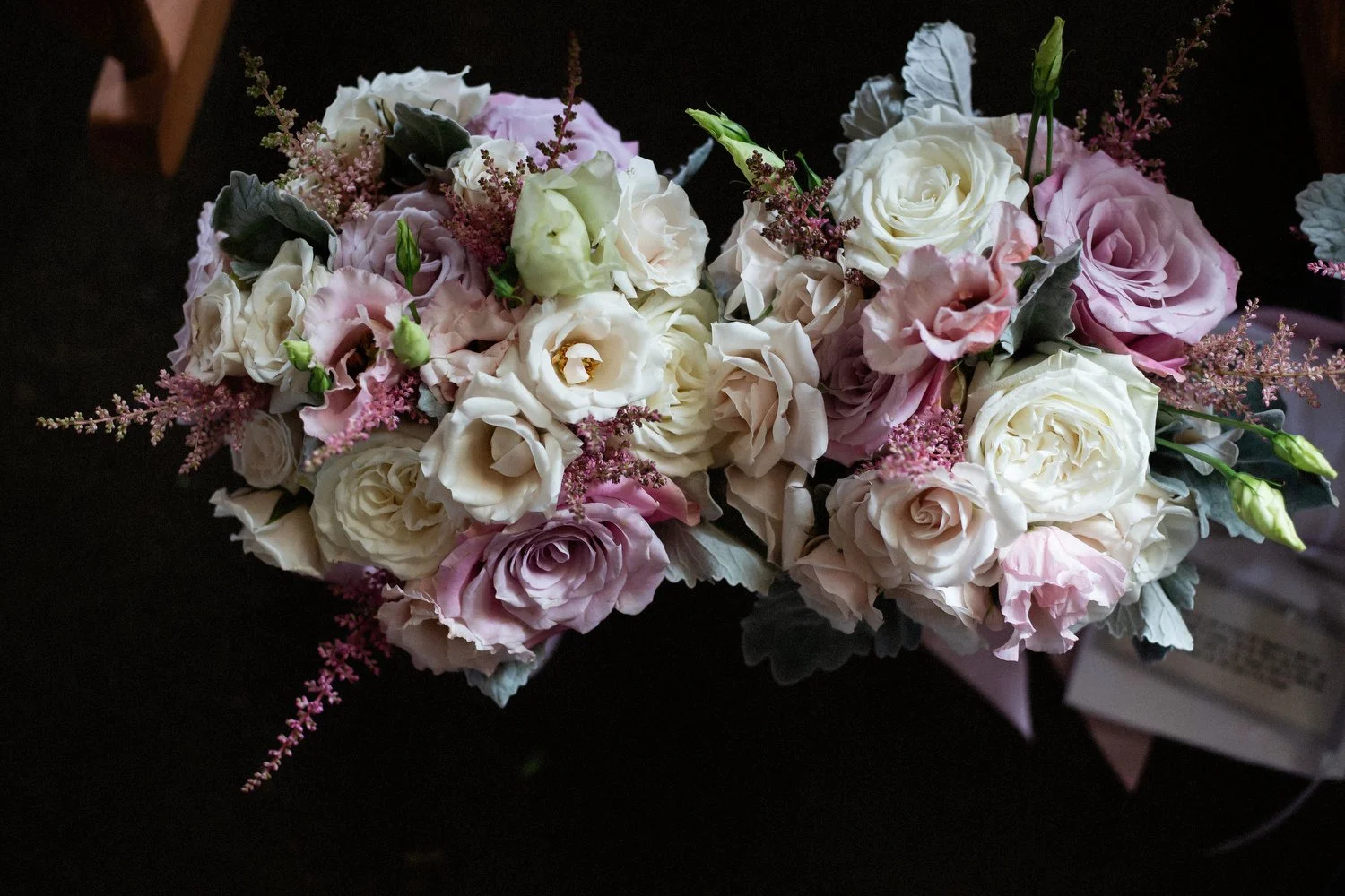 A pair of bouquets with purple, white and pink flowers are side-by-side in this aerial image.