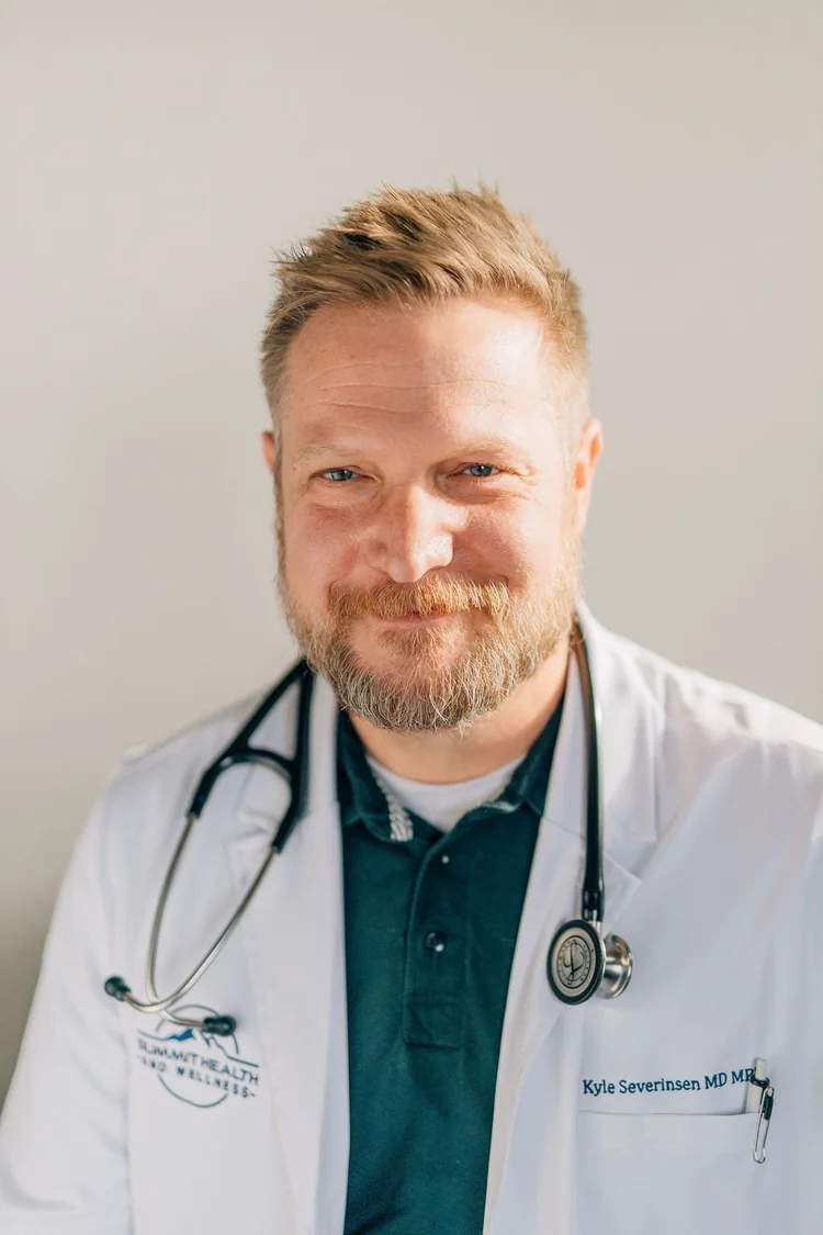 Dr. Kyle Severinsen smiling in a white coat with a stethoscope