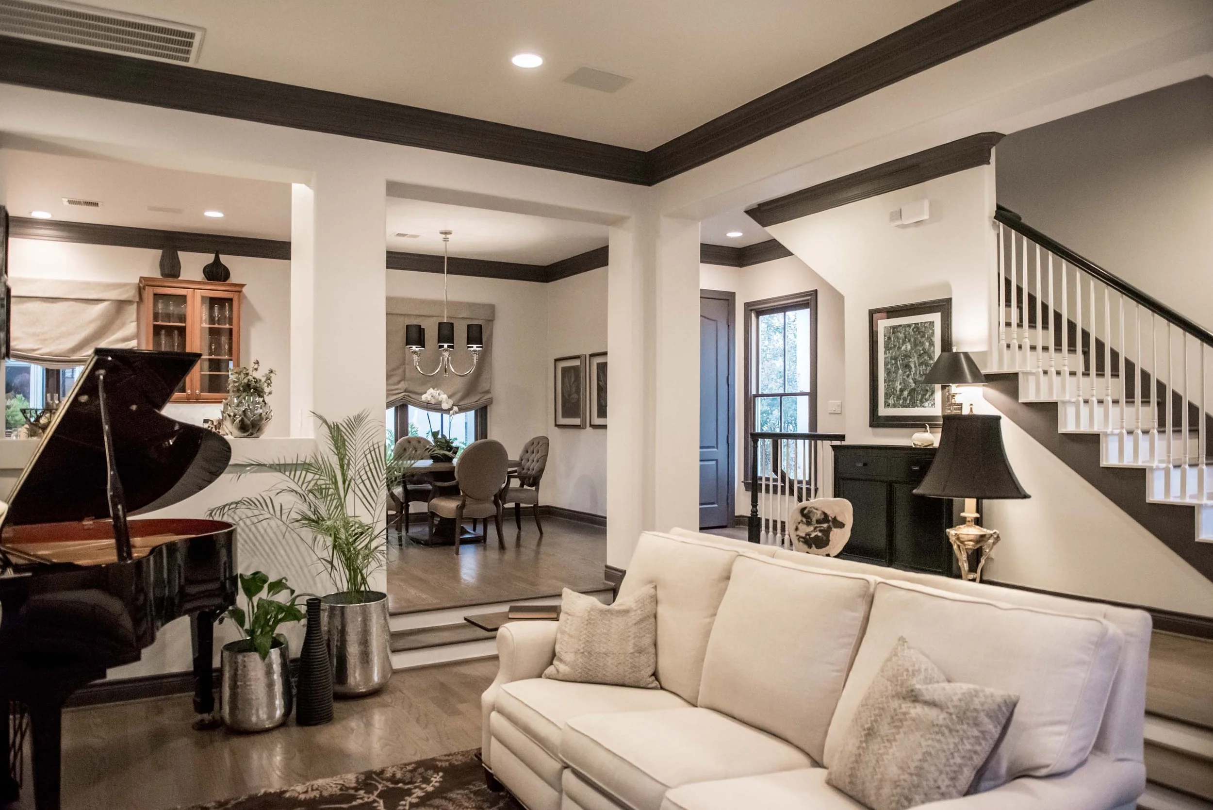 Transitional stle living area with white walls, dark trim, white furniture and wood floors