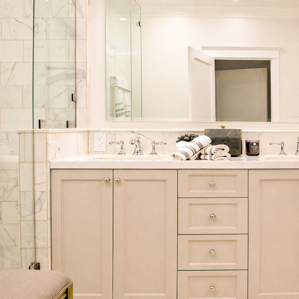 Custom bathroom vanity in a Spaulding Square Tudor remodel with marble countertop, chrome fixtures, and detailed paneled cabinetry