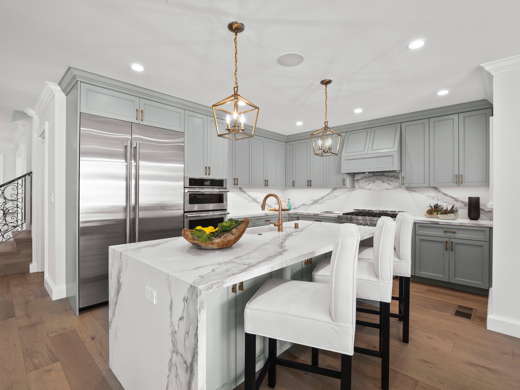 Hancock Park kitchen remodel with large marble island, brass pendant lighting, custom cabinetry, and integrated open layout